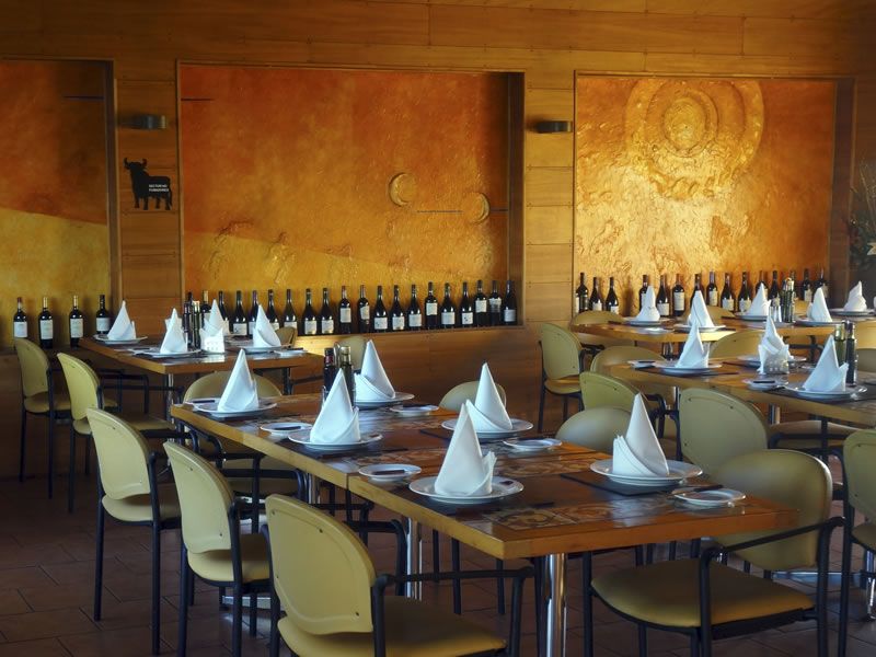 Salón amplio de Los Ganaderos con la vinoteca al fondo